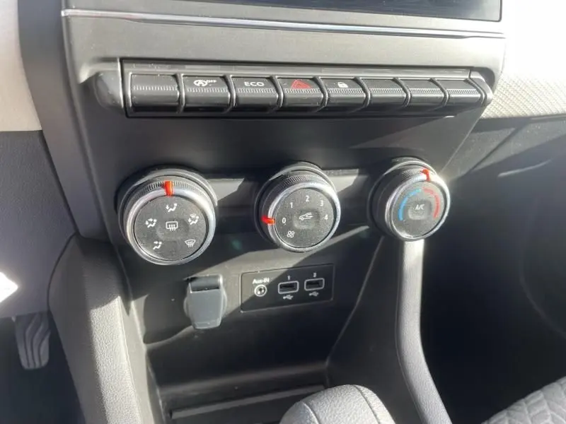 Gros plan sur les commandes de climatisation et boutons de fonction du tableau de bord d'une Renault Clio V gris foncé métal 2023.