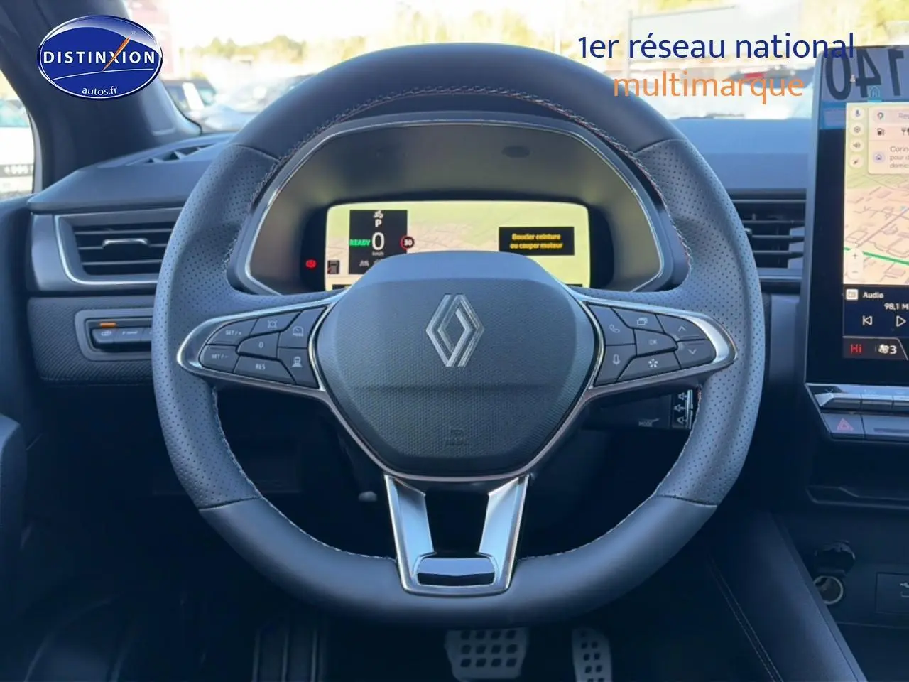 Vue intérieure centrée sur le volant cuir perforé du Renault Captur gris cassiopée avec tableau de bord numérique et écran tactile.