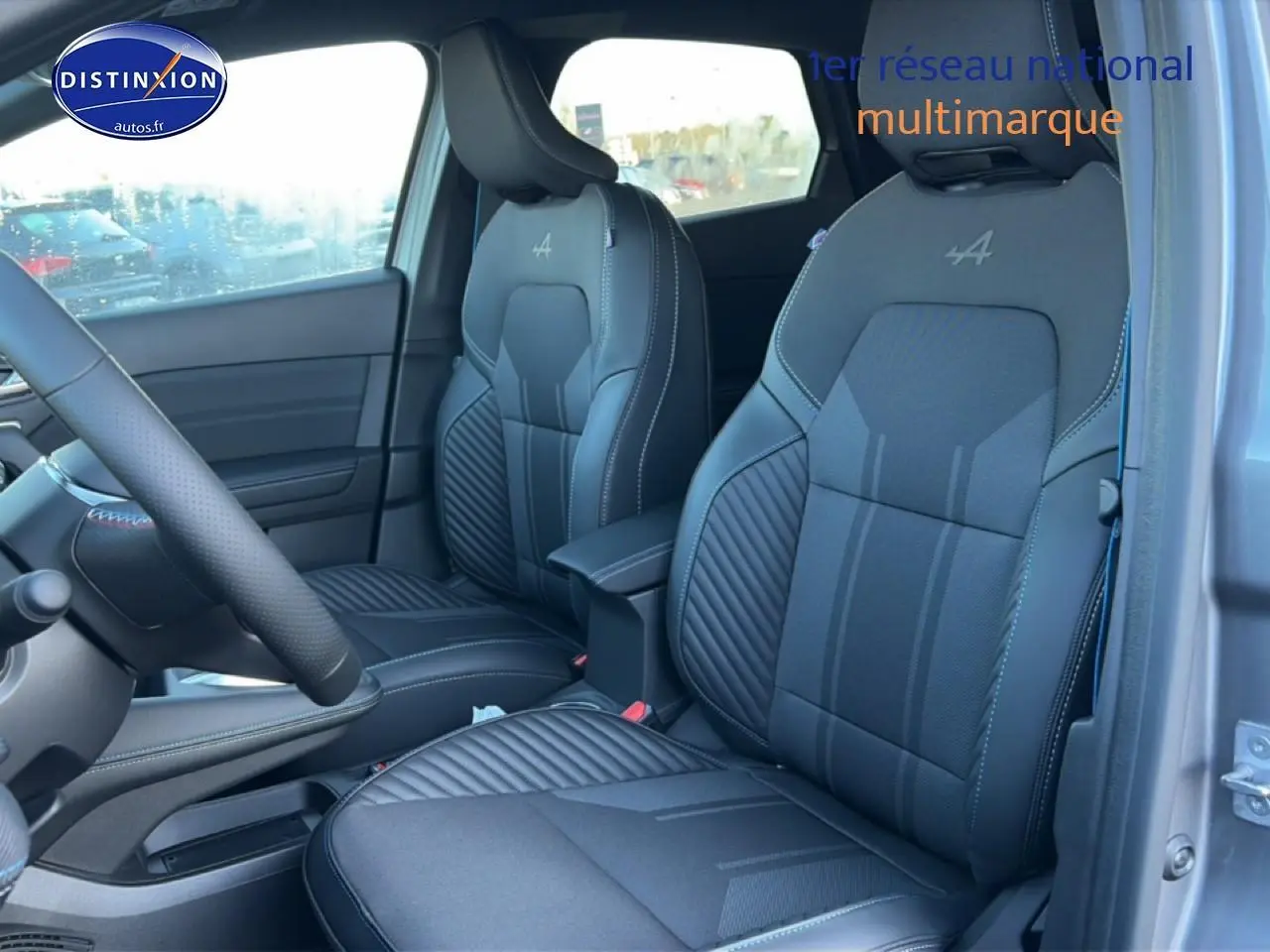 Vue intérieure côté avant droit du Renault Captur 2025 avec sièges sport gris et logo Alpine brodé.