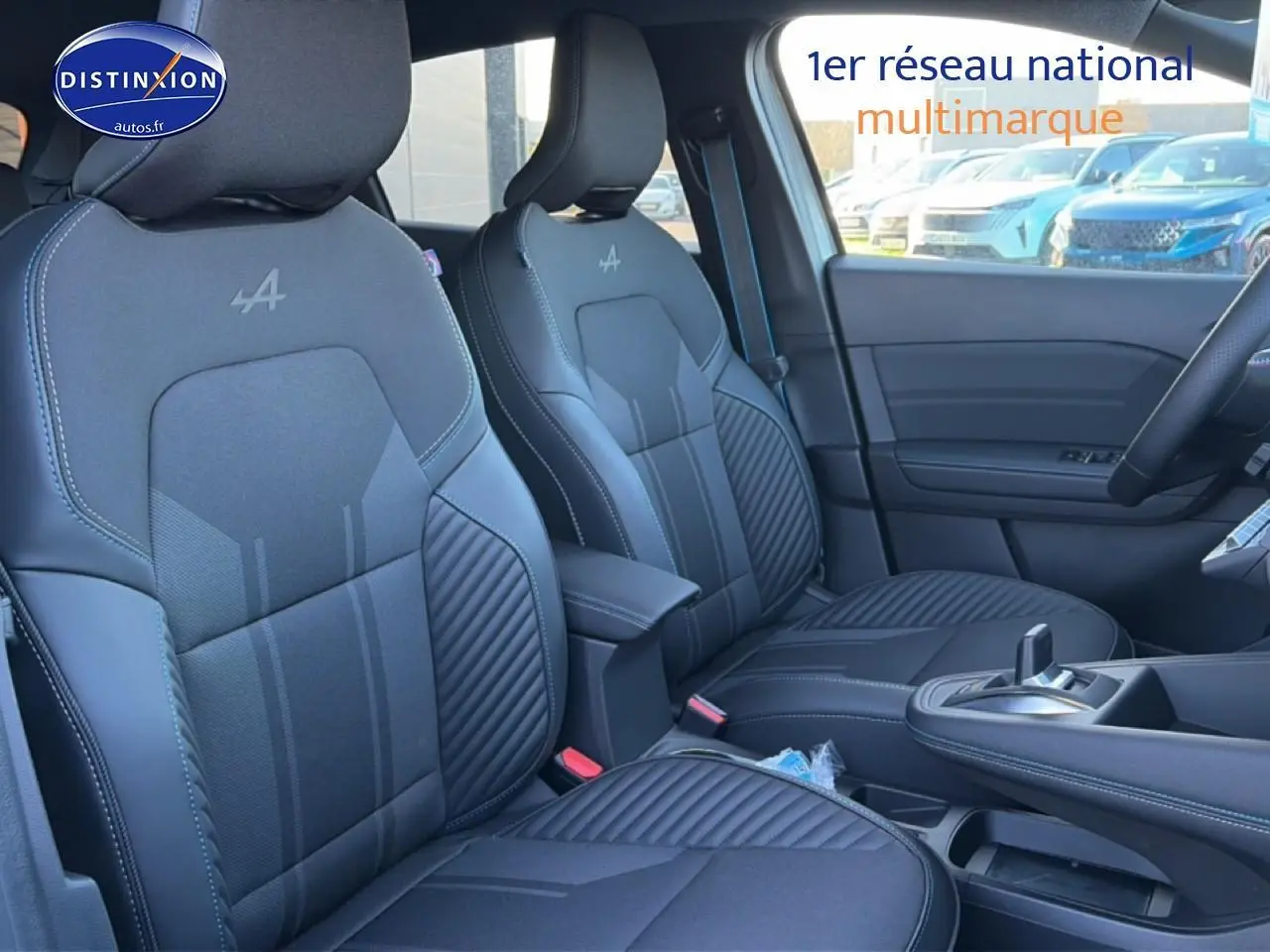 Vue intérieure côté avant droit des sièges noirs avec logo Alpine et accoudoir central du Renault Captur 2025 hybride.