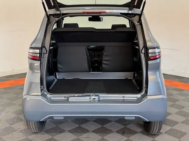 Vue arrière ouverte d'une Aixam Ambition 0.5 City Pack gris foncé, montrant l'espace de coffre et l'intérieur des sièges.