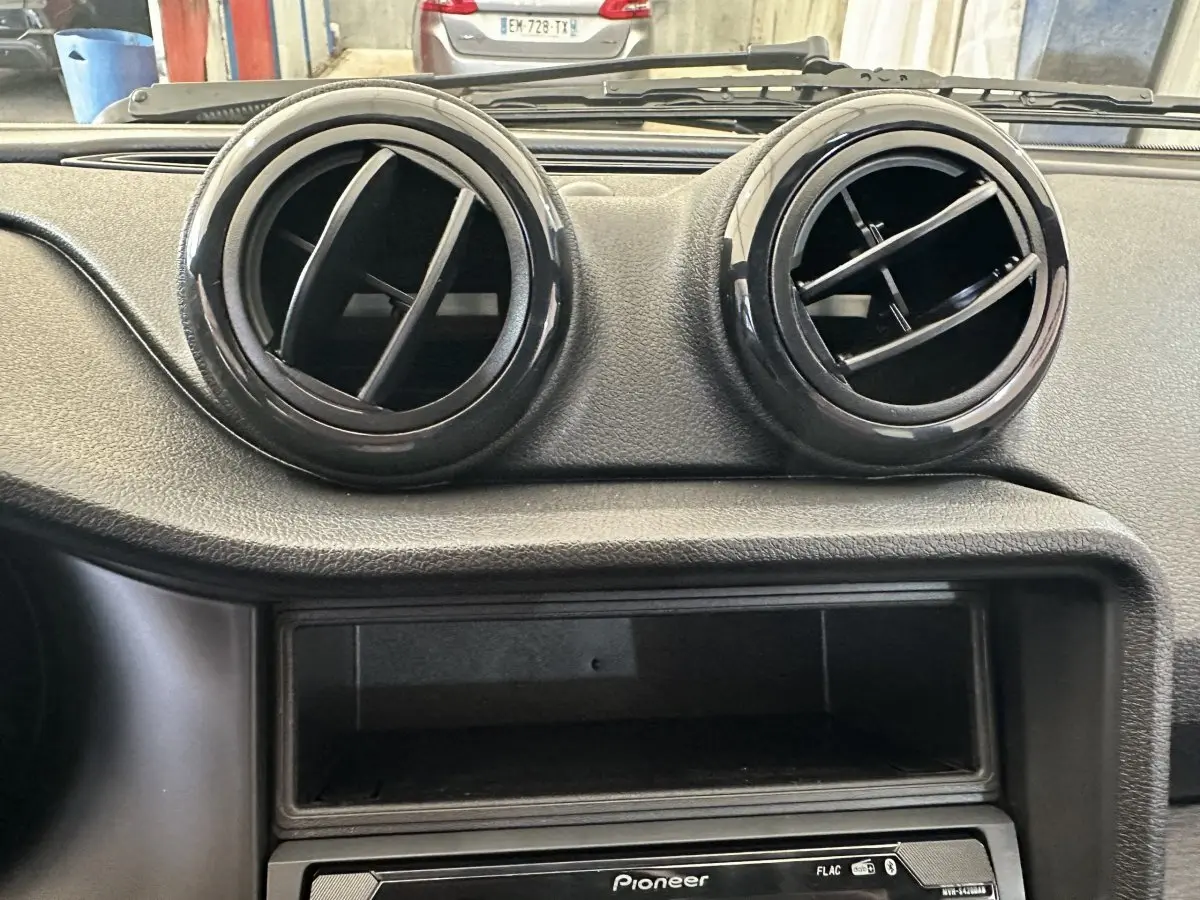 Détail intérieur montrant les deux aérateurs ronds noirs du tableau de bord de l'AIXAM AMBITION 0.5 CITY PACK 2026.