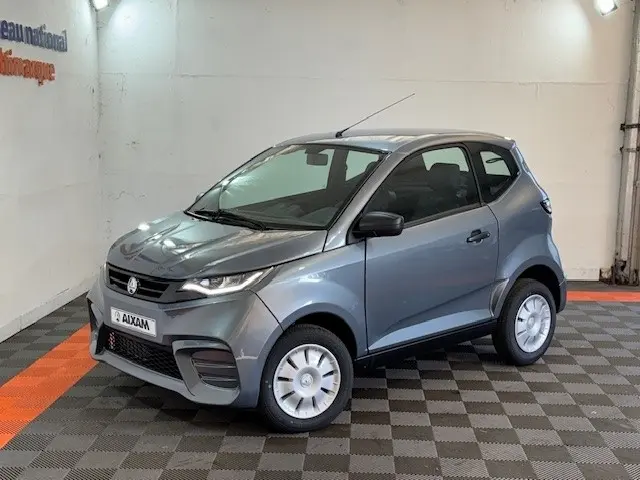 Vue 3/4 avant droite d'une Aixam Ambition 0.5 City Pack gris foncé avec rétroviseur caméra côté conducteur.