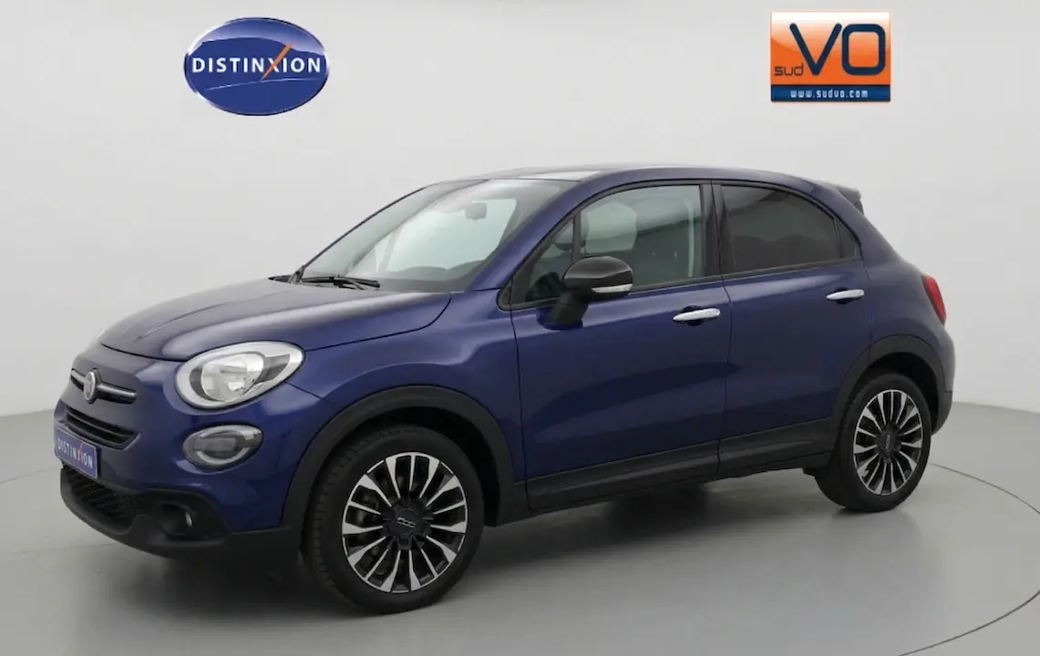 Vue 3/4 avant droit d'un FIAT 500X bleu 2024 avec jantes noires et chromées, phares ronds et rétroviseurs noirs.