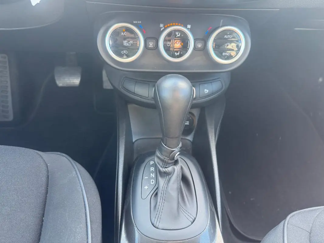 Le levier de vitesse automatique et les commandes de climatisation manuelle du Fiat 500X bleu, vue intérieure centrée.