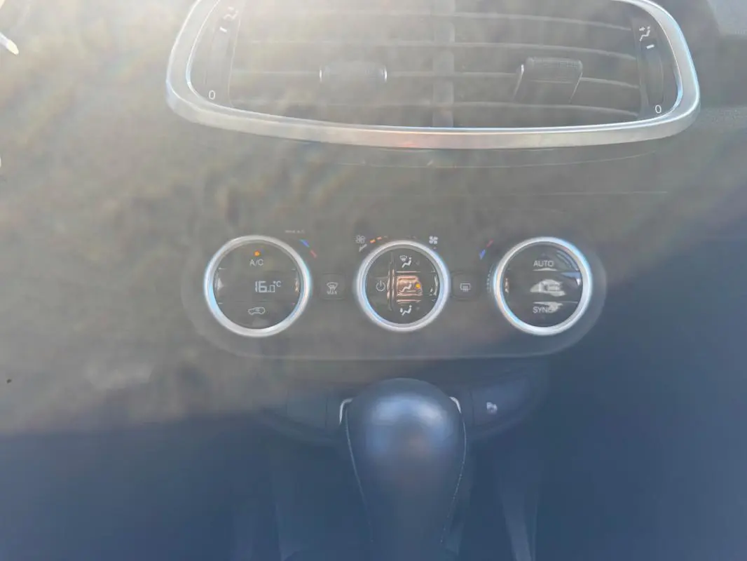 Gros plan sur la console centrale du Fiat 500X bleu MY23, montrant les commandes de climatisation et le levier de vitesse automatique.