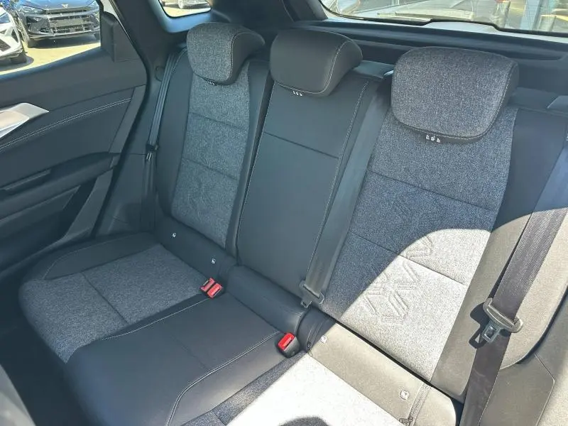 Vue intérieure sur la banquette arrière bicolore gris clair et noir du Renault Austral 2025 en hybride blanc nacré.