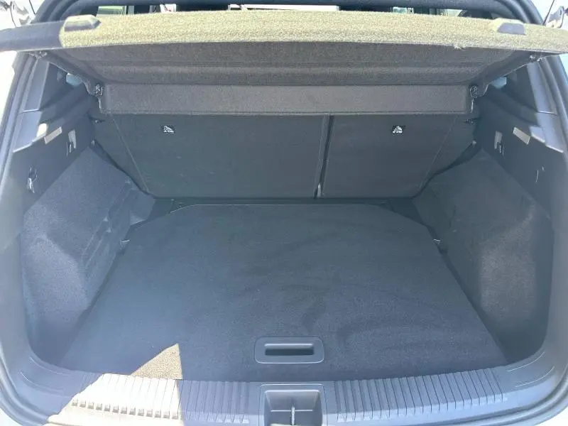 Vue du coffre ouvert du Renault Austral blanc nacré, montrant un espace de rangement propre et bien agencé avec cache-bagages.