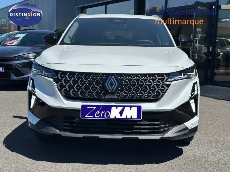 Vue frontale d'un Renault Austral blanc nacré brillant avec calandre noire à motif géométrique et feux LED distinctifs.