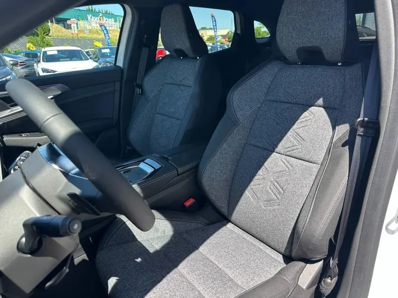 Vue intérieure côté conducteur du Renault Austral 2025, sièges tissu gris clair avec motifs géométriques.