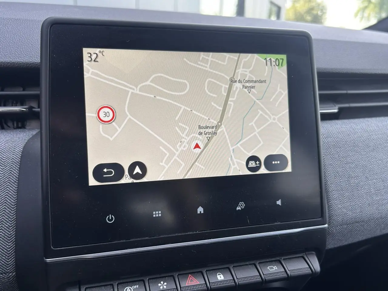 Écran tactile central affichant la navigation dans l’habitacle de la Renault Clio Gris Rafale, vue de face rapprochée.