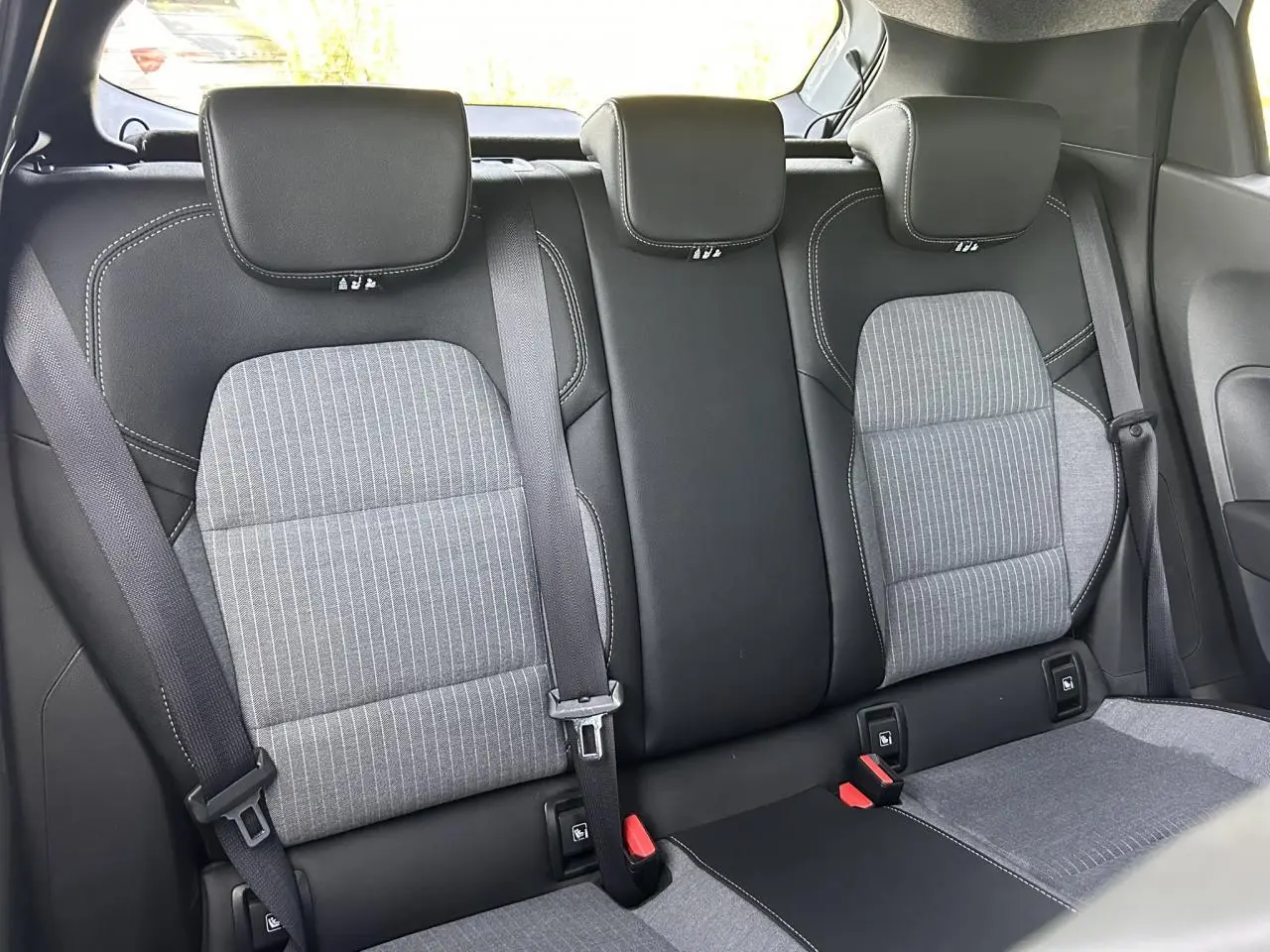 Vue arrière intérieure des sièges arrière gris et noirs de la Renault Clio V TCE 90 Techno 2025, avec ceintures attachées.