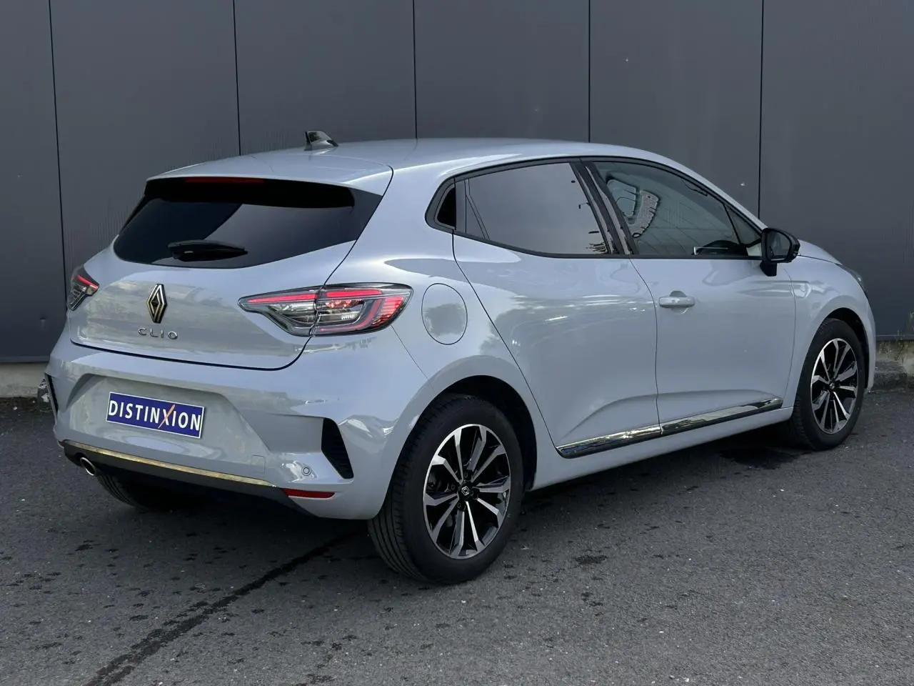 Vue 3/4 arrière droite d'une Renault Clio 2025 gris Rafale avec jantes alliage et vitres surteintées.