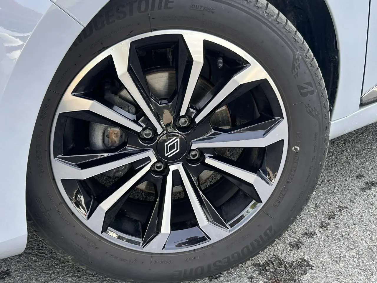 Gros plan sur la jante alliage diamantée 16 pouces noire et argentée de la Renault Clio Gris Rafale côté droit.