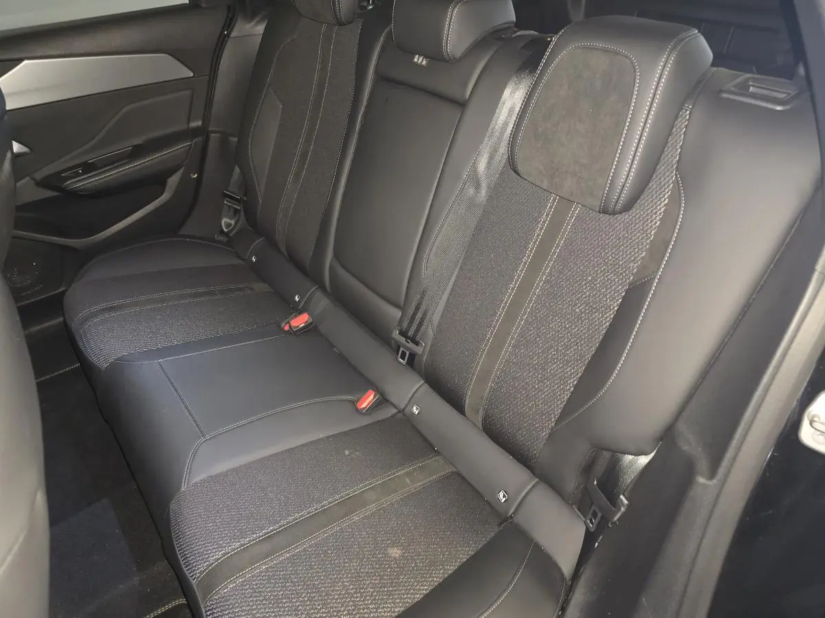 Vue intérieure des sièges arrière en cuir noir et tissu de la Peugeot 308 SW GT hybride rechargeable 2024.