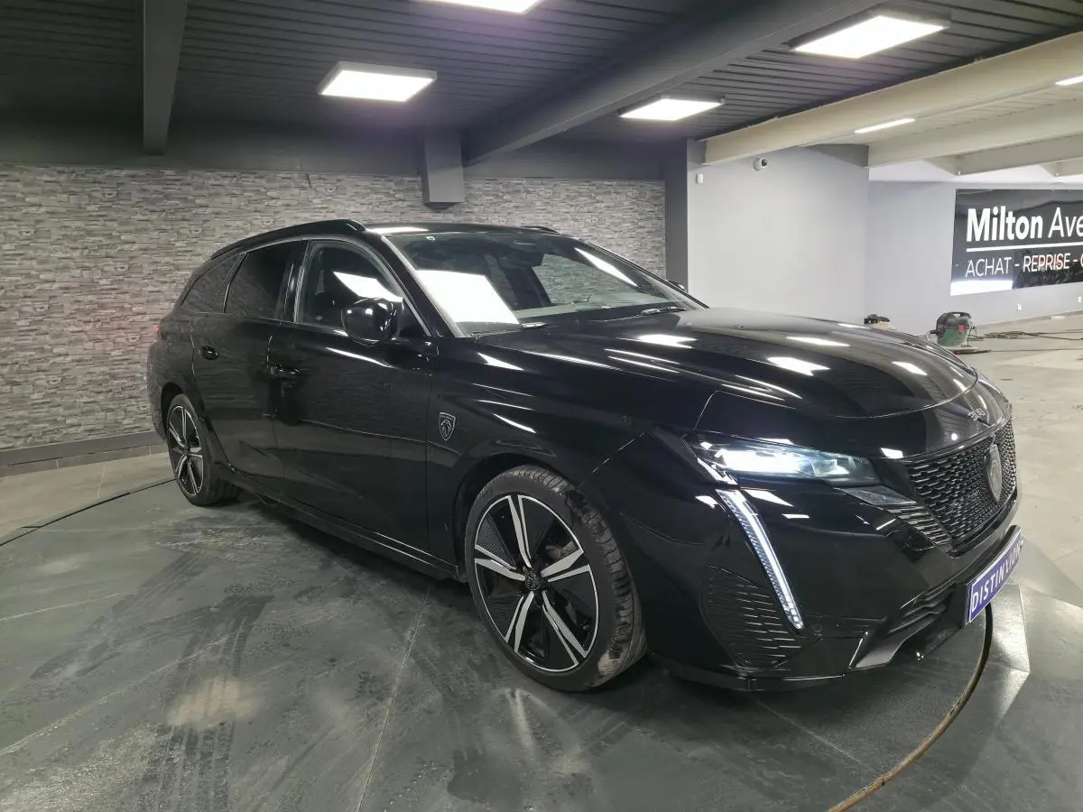 Peugeot 308 SW GT noire vue en 3/4 avant droit, avec feux LED et jantes alliage 18 pouces distinctives.