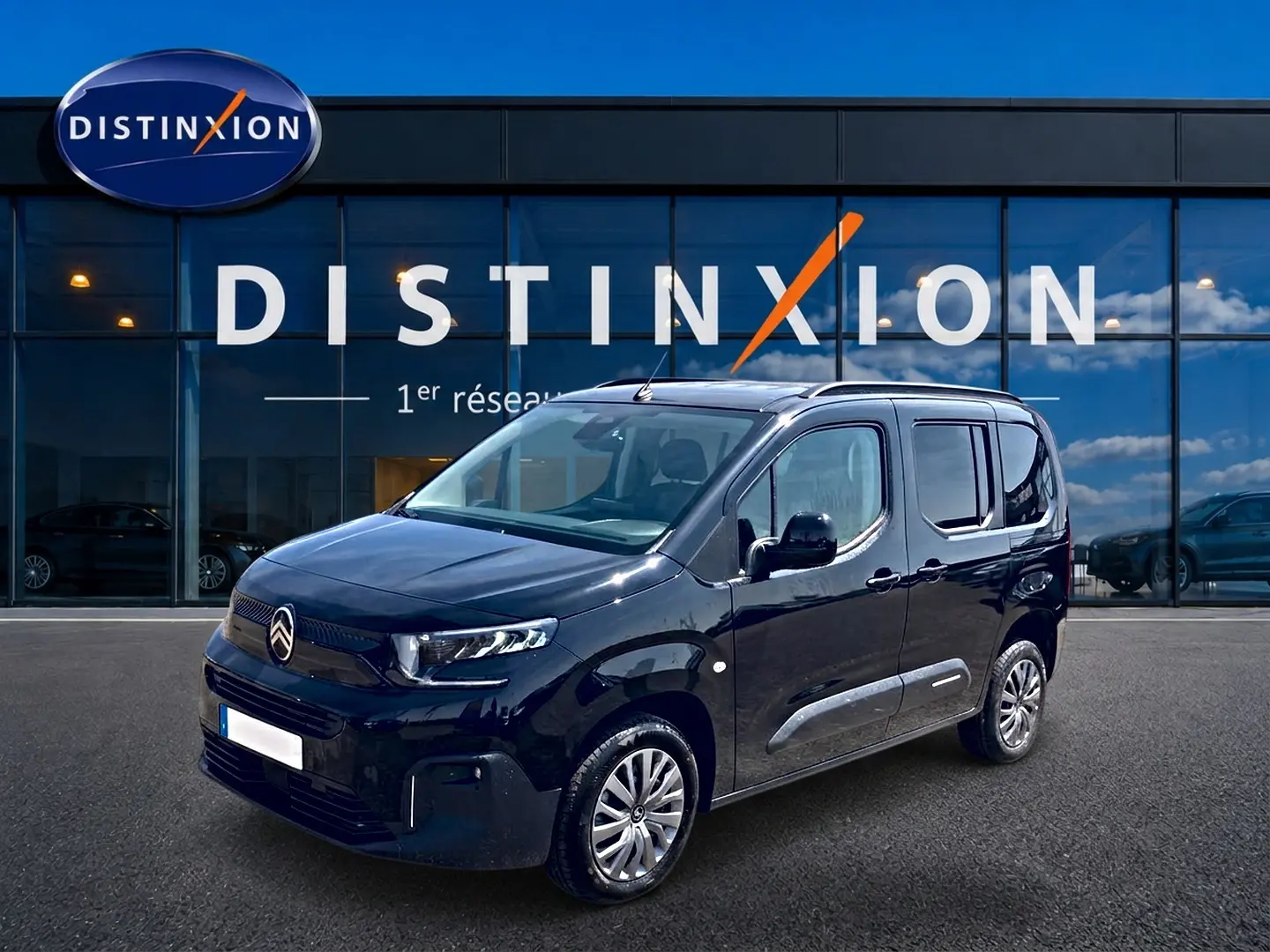 Citroën Berlingo noir vue 3/4 avant droit, avec barres de toit et poignées ton carrosserie visibles.