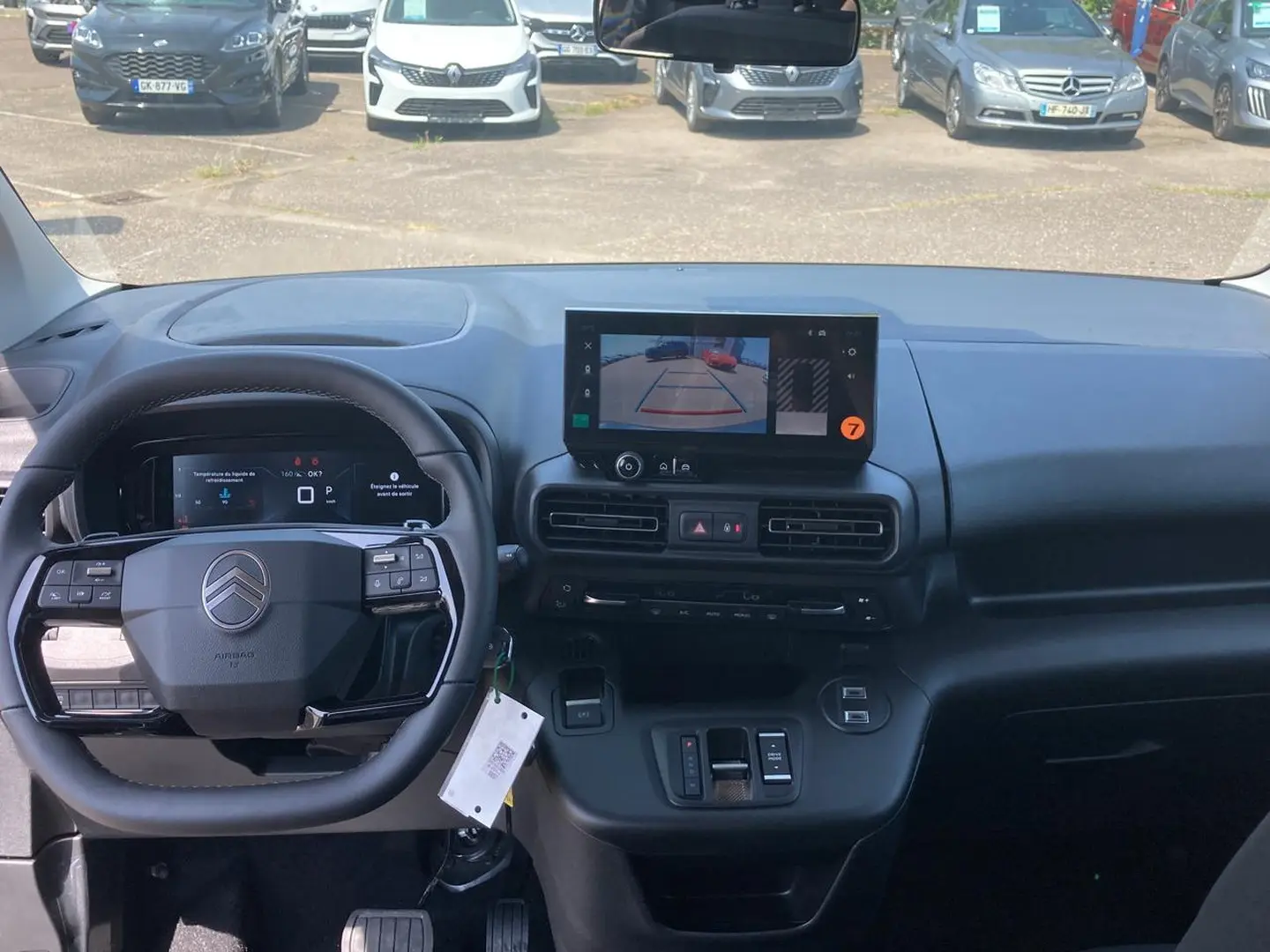 Vue intérieure avant du Citroën Berlingo noir 2026, volant multifonction et écran tactile affichant la caméra de recul.