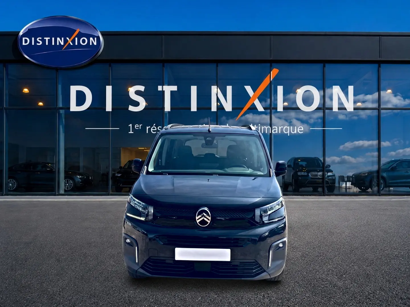 Vue avant d'un Citroën Berlingo noir 2026 avec phares LED et barres de toit, devant une vitrine Distinxion.