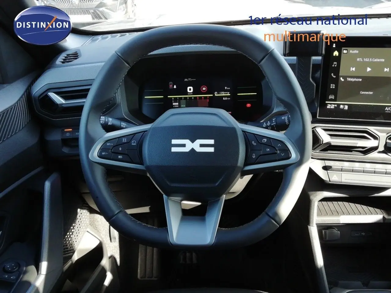 Vue rapprochée du volant noir et gris du Dacia Duster 2026 TCE MHEV 140CH Journey avec tableau de bord digital et écran central.