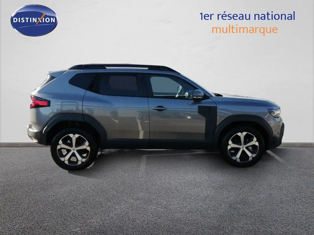 Profil droit du Dacia Duster TCE MHEV 140ch Journey gris schiste métal avec jantes bi-ton et protections noires.