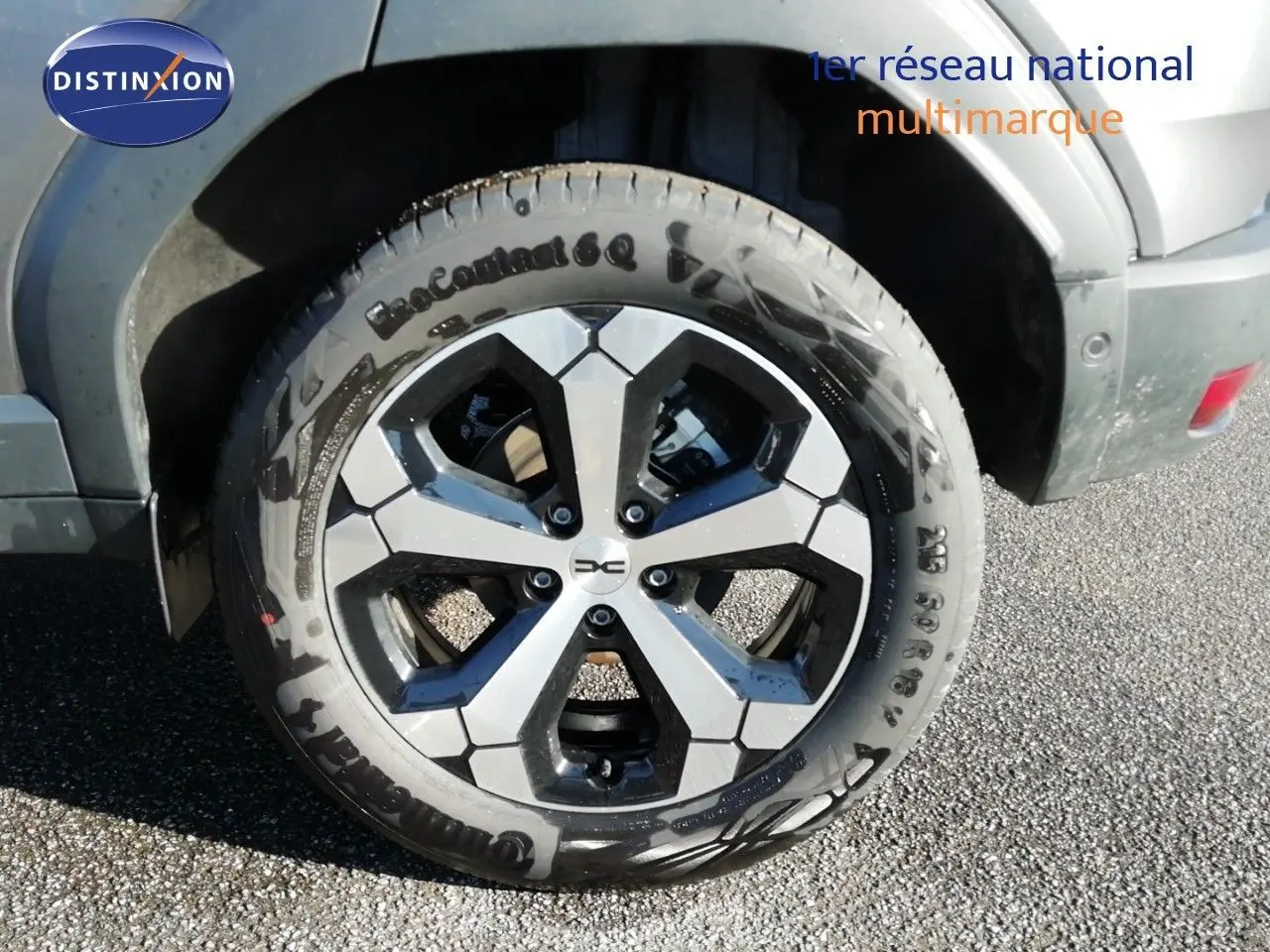 Gros plan sur la roue avant droite du Dacia Duster gris schiste métal avec jante alliage bicolore.