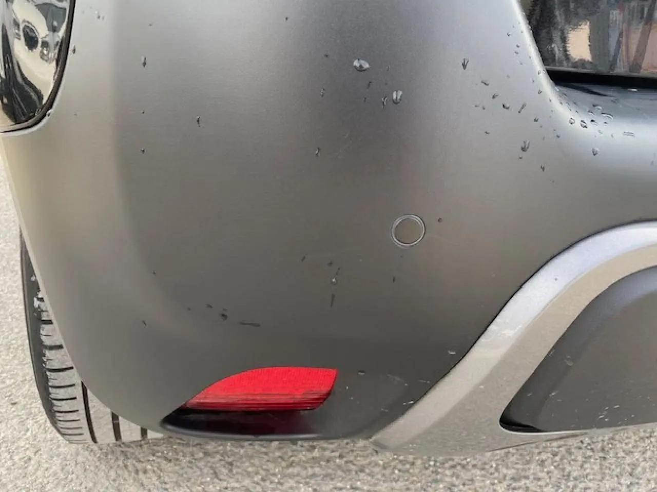 Gros plan sur le coin arrière droit noir mat du Citroën C3 Aircross avec feu rouge et pare-chocs gris.