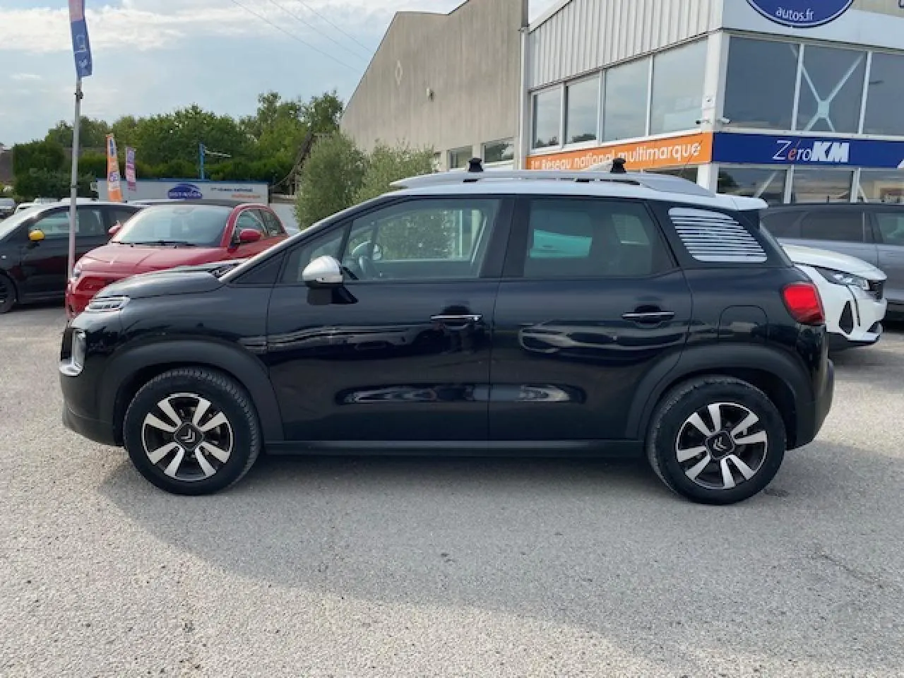 Profil côté gauche d'un Citroën C3 Aircross noir 2019 avec toit blanc et jantes distinctives en concession.