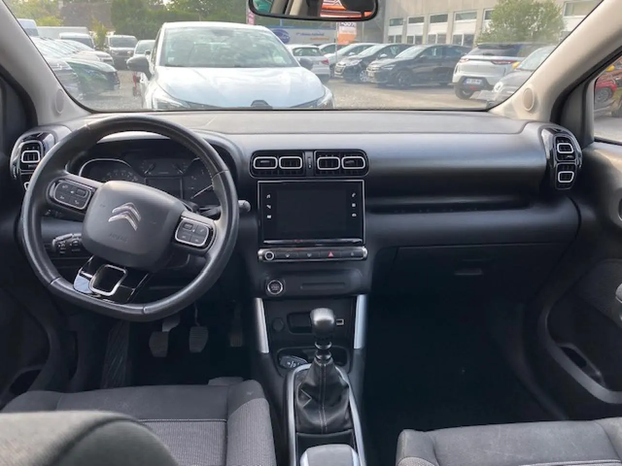 Intérieur noir du Citroën C3 Aircross 2019, vue frontale du tableau de bord avec volant multifonction et boîte manuelle.