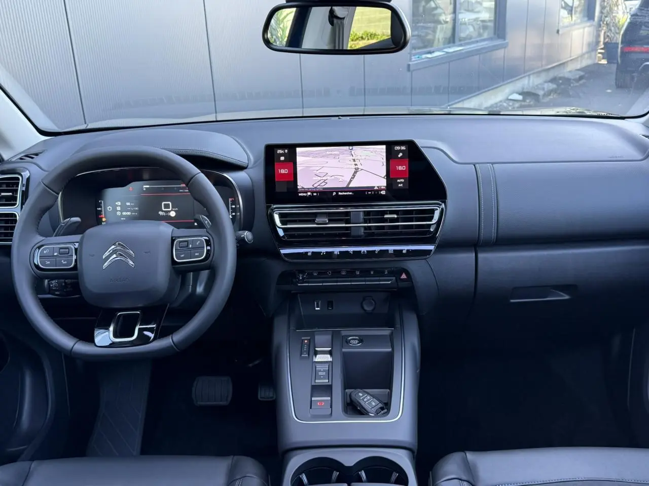 Intérieur noir du Citroën C5 Aircross 2025 vu de face, tableau de bord avec écran tactile et volant multifonction.