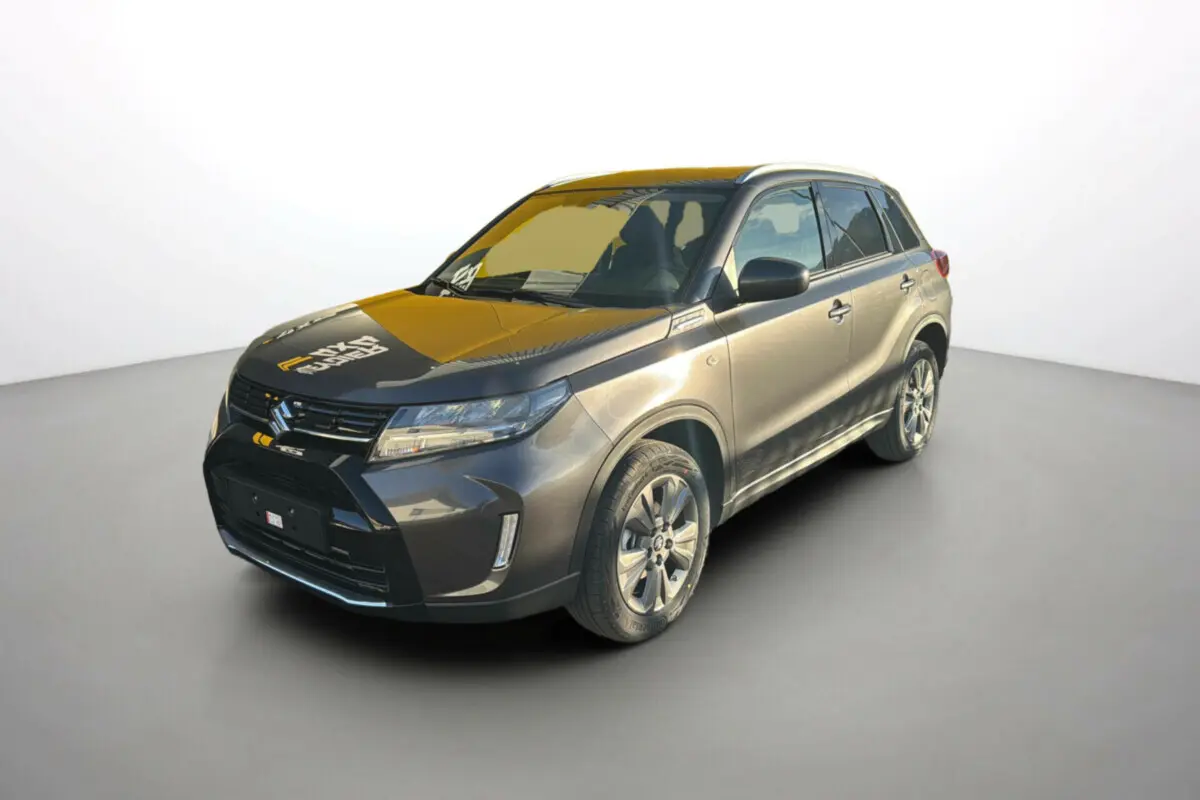 Suzuki Vitara 2025 gris silky silver en 3/4 avant droit, avec calandre noire et jantes alliage visibles.
