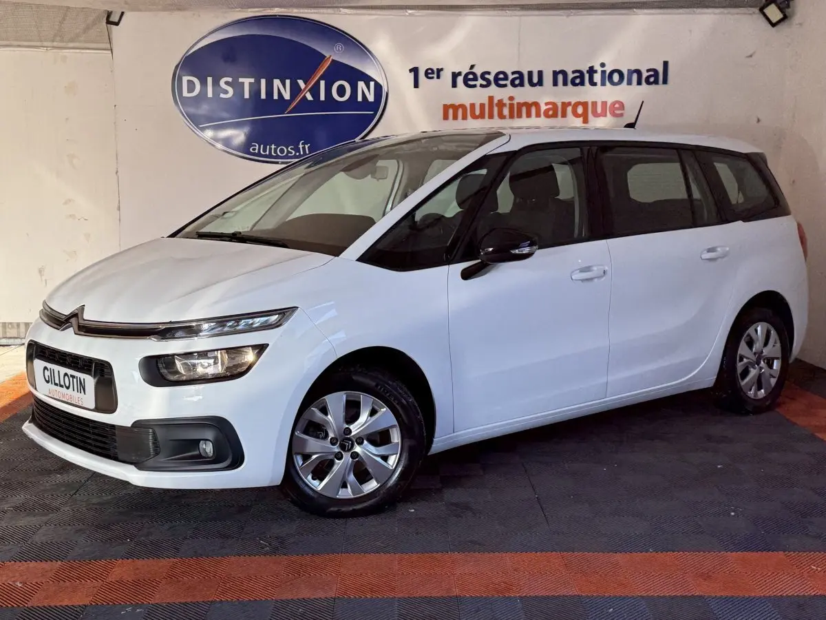 Vue 3/4 avant droit d'un Citroën Grand C4 Spacetourer blanc, avec jantes alliage et calandre distinctive.