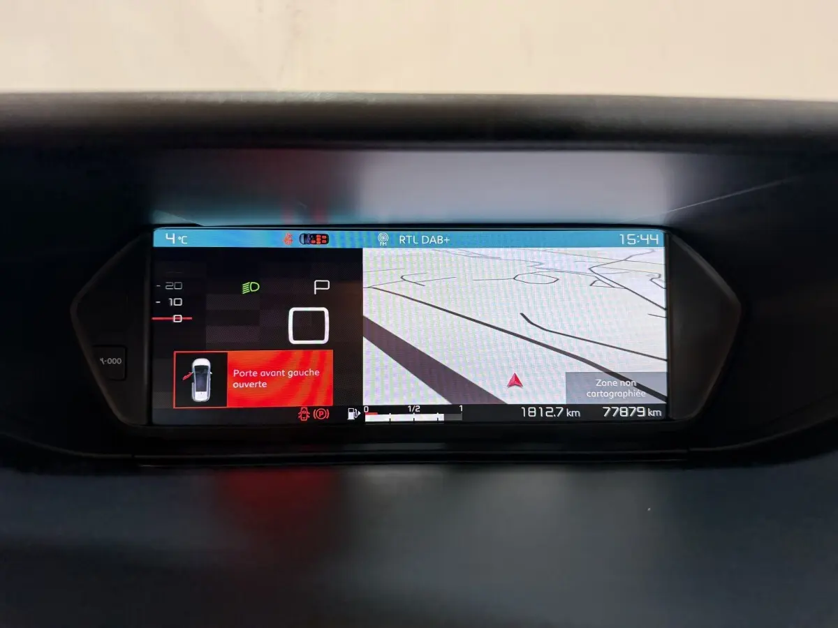 Affichage numérique du tableau de bord du Citroën Grand C4 Spacetourer blanc, avec navigation et alerte porte avant gauche ouverte.
