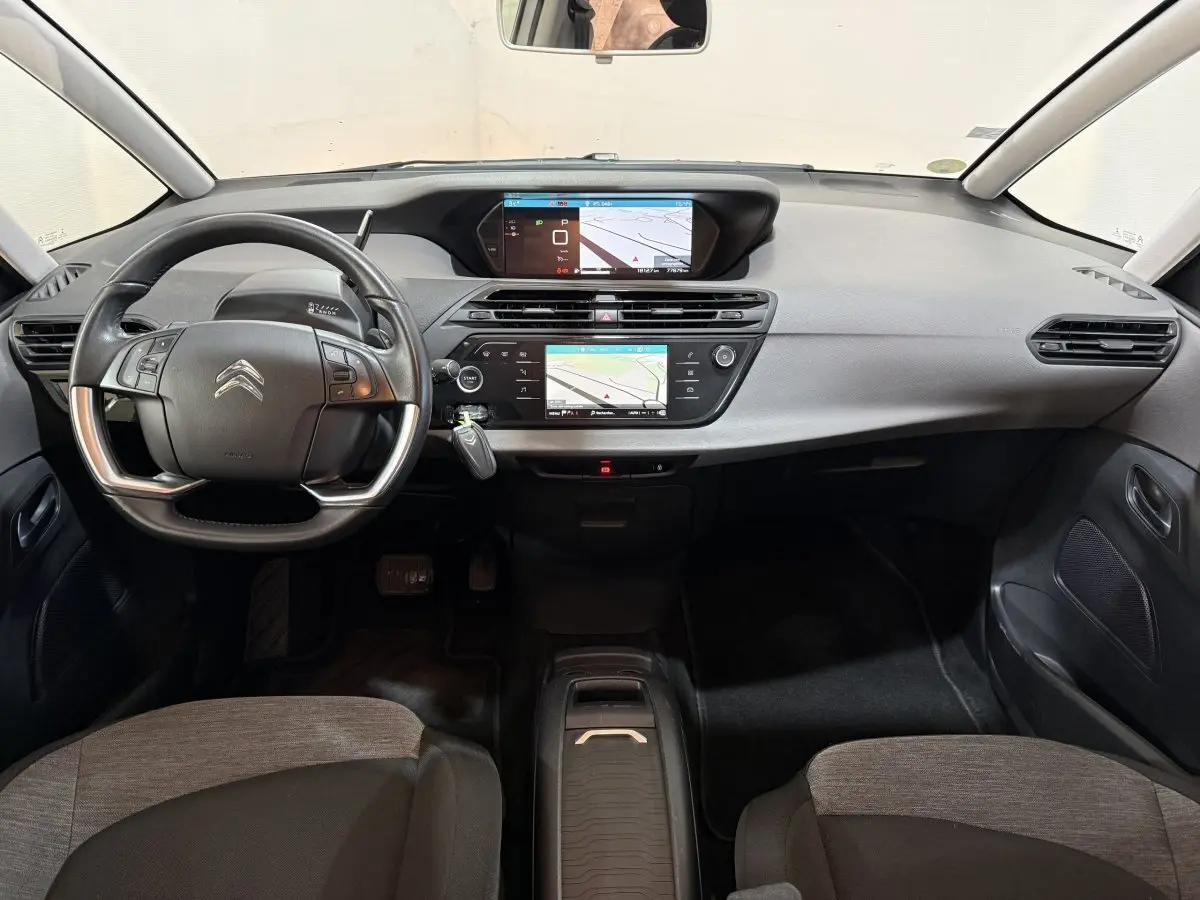 Vue intérieure avant du tableau de bord gris et noir du Citroën Grand C4 Spacetourer avec double écran tactile et volant multifonction.