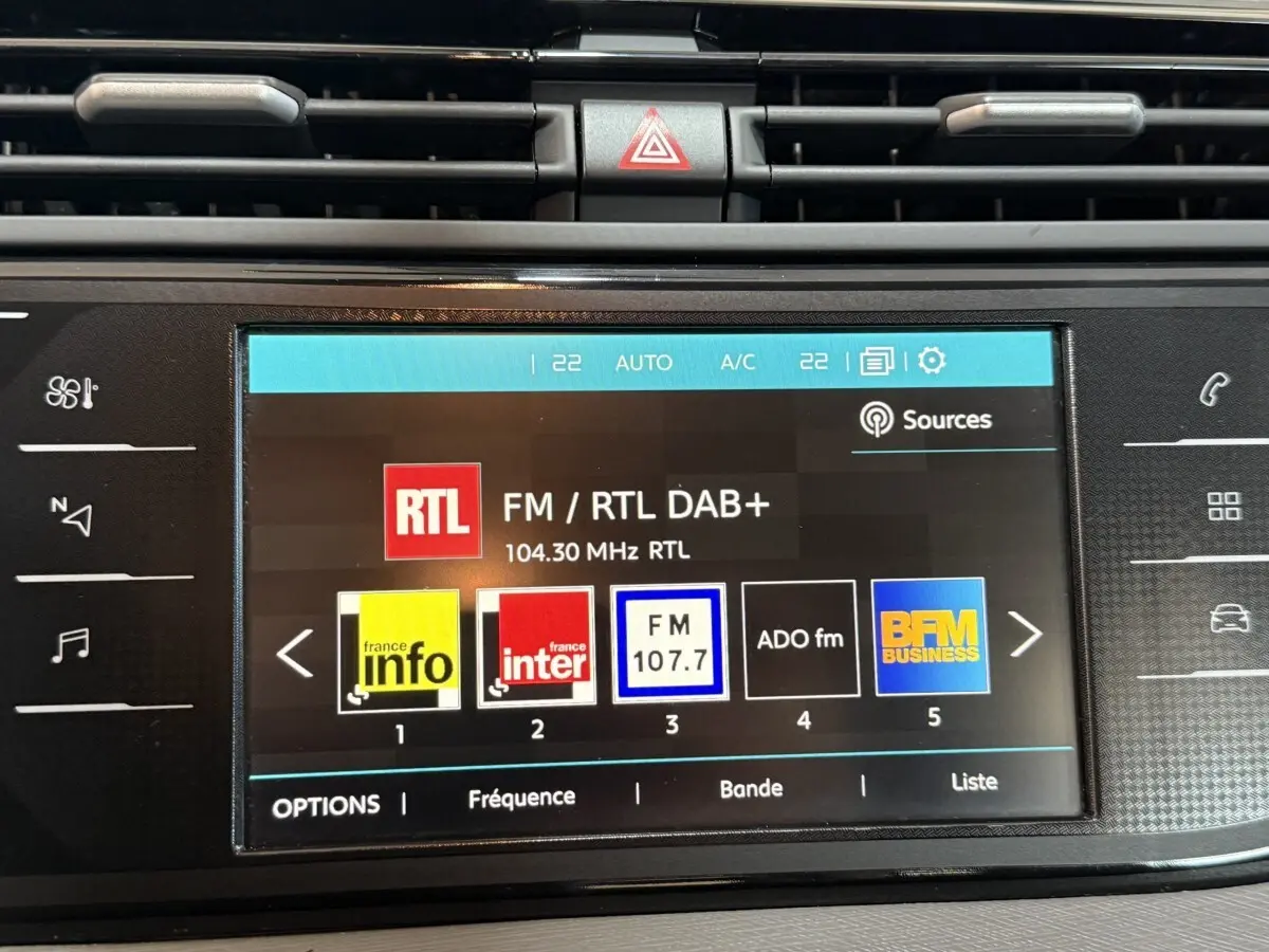 Écran tactile central de la Citroën Grand C4 Spacetourer blanc, affichant les stations radio FM avec commandes tactiles.