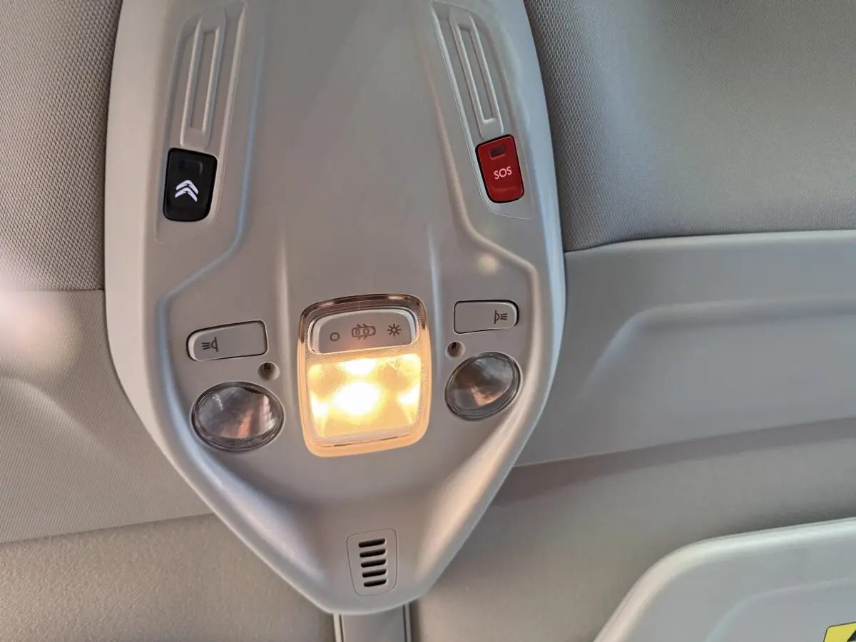 Vue rapprochée du plafonnier gris clair avec éclairage et boutons SOS et assistance du Citroën Grand C4 Spacetourer blanc.
