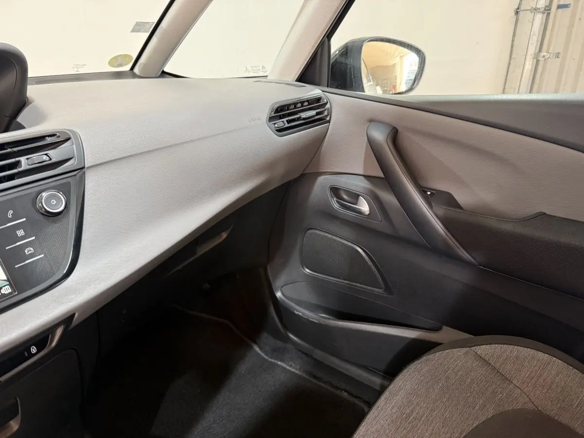 Vue intérieure côté passager du tableau de bord et de la porte d’une Citroën Grand C4 Spacetourer blanc, finition Business.