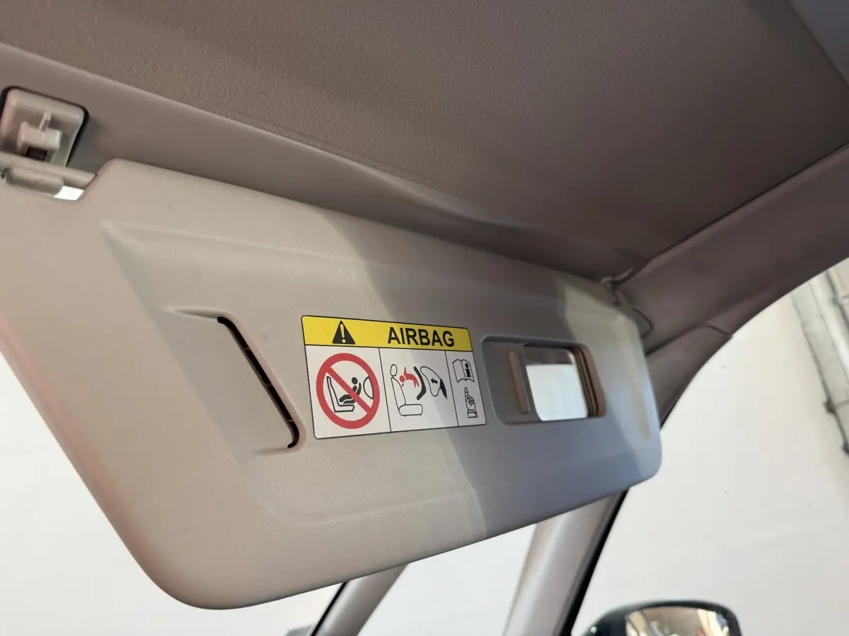 Gros plan sur le pare-soleil intérieur côté conducteur du Citroën Grand C4 Spacetourer blanc avec avertissement airbag visible.