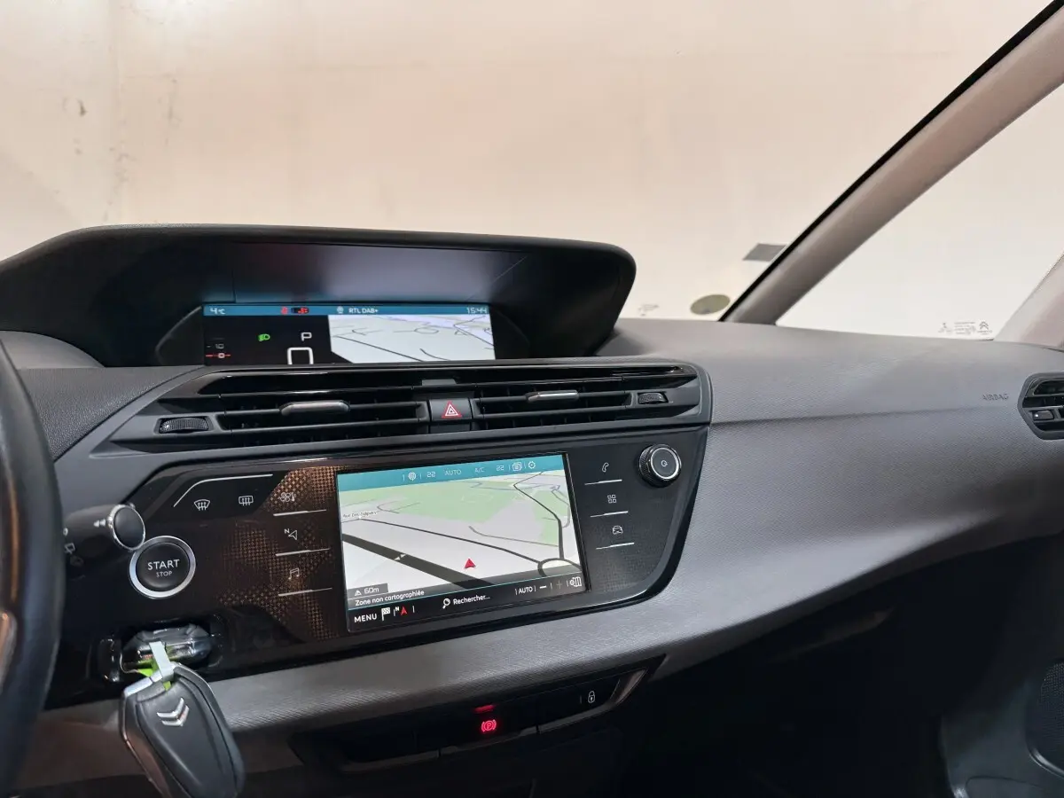 Vue intérieure du tableau de bord du Citroën Grand C4 Spacetourer blanc, avec écran tactile de navigation central.