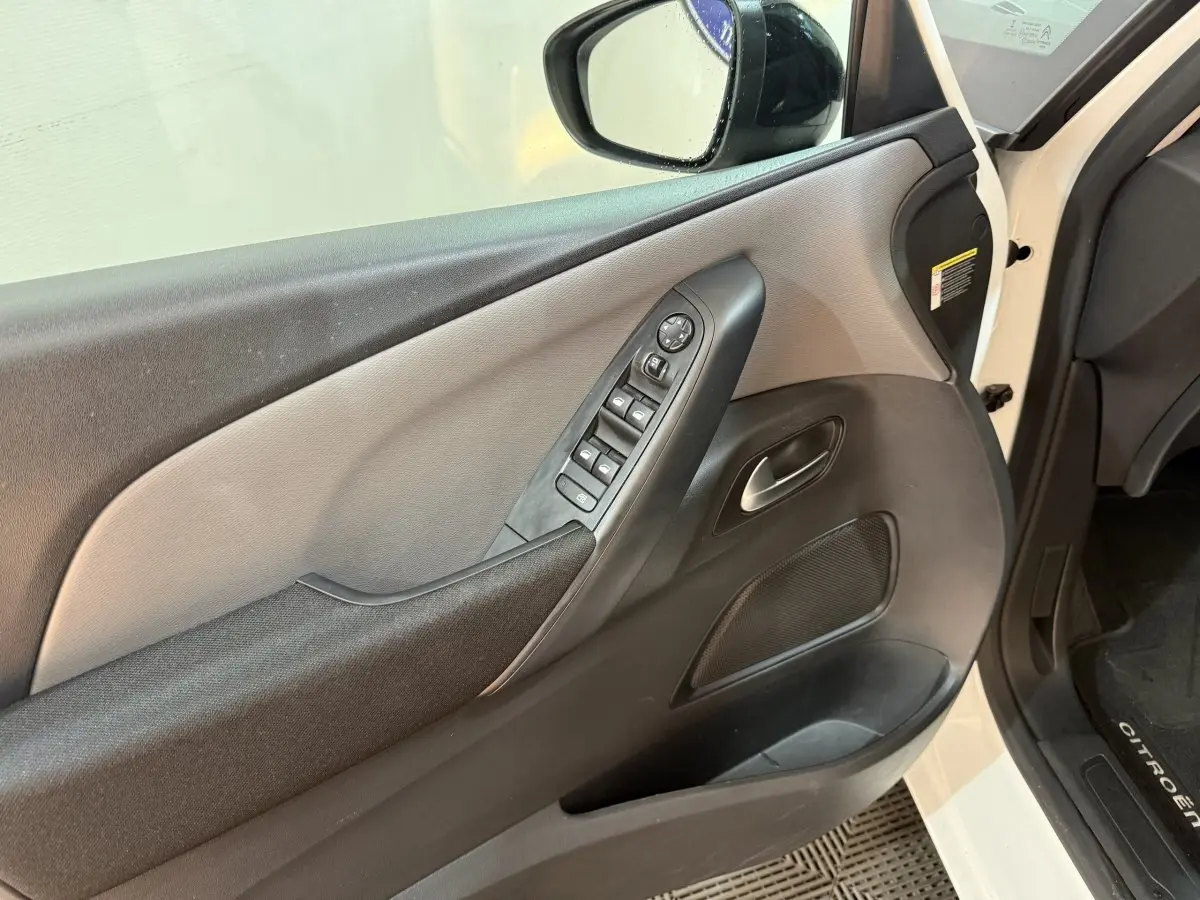 Intérieur côté conducteur du Citroën Grand C4 Spacetourer blanc 2021, avec panneau de porte noir et gris et commandes électriques.