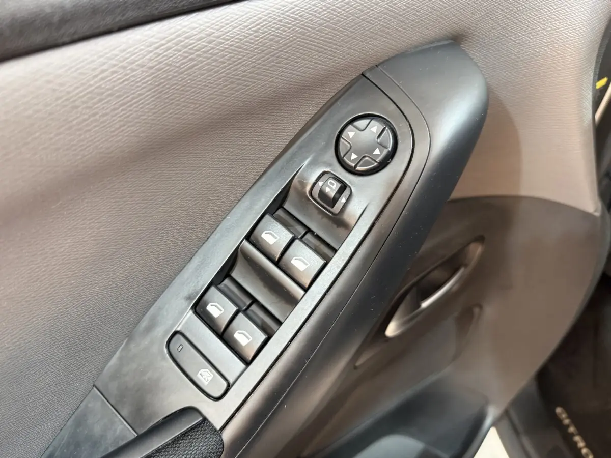 Gros plan sur les commandes des vitres et rétroviseurs côté conducteur du Citroën Grand C4 Spacetourer blanc, intérieur noir.