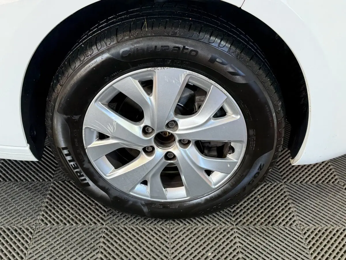 Gros plan sur la roue avant gauche avec jante argentée et pneu Pirelli sur Citroën Grand C4 Spacetourer blanc.