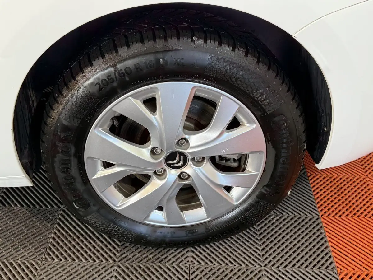 Gros plan sur la roue avant droite blanche du Citroën Grand C4 SpaceTourer avec jante argentée et pneu Continental.