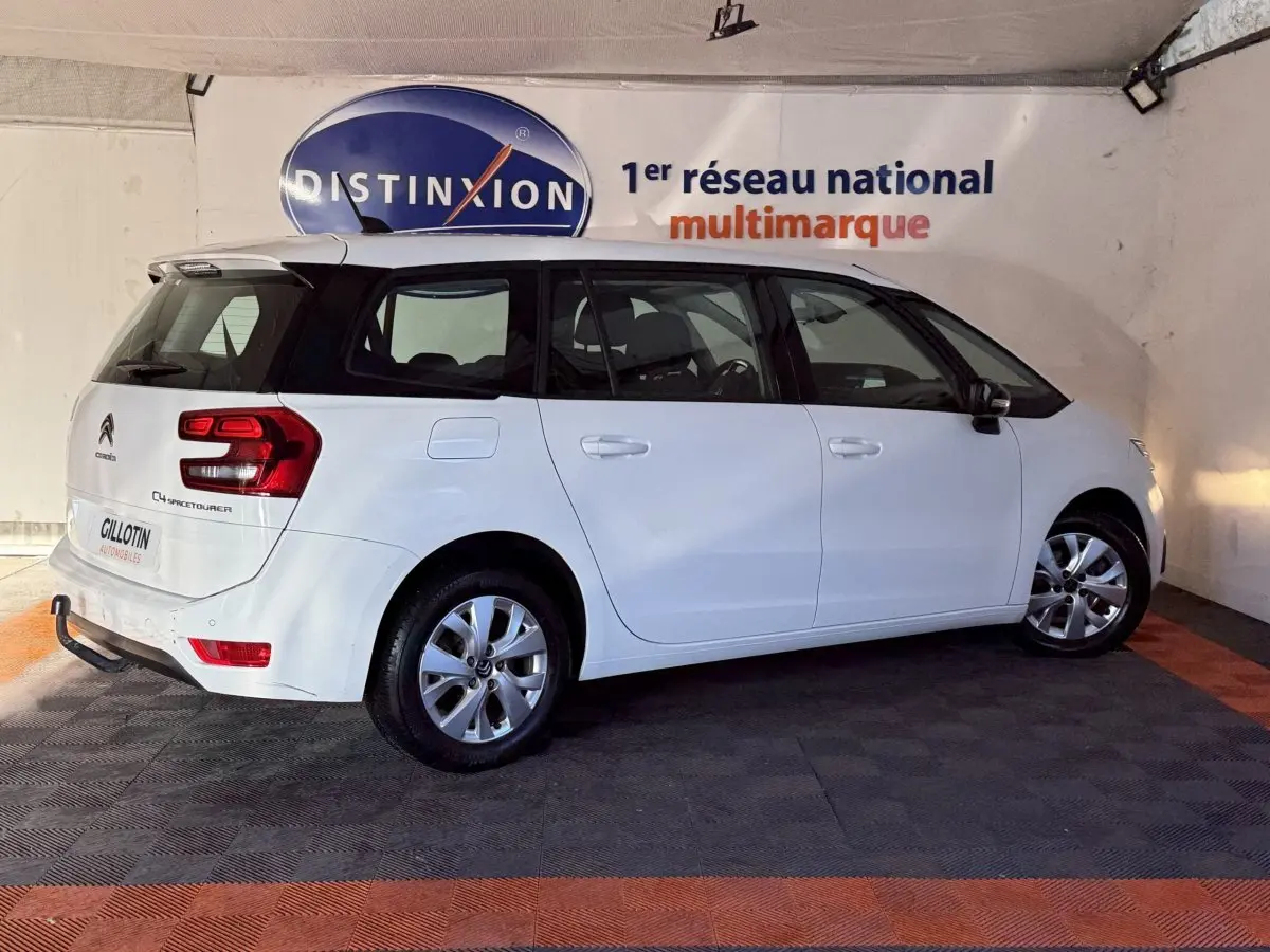 Vue 3/4 arrière droite d'un Citroën Grand C4 Spacetourer blanc, avec feux arrière distinctifs et jantes alliage.