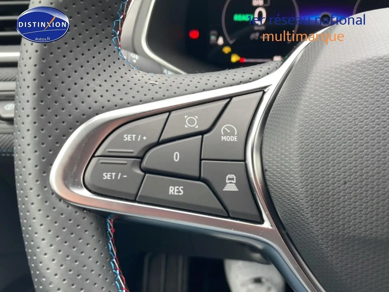 Gros plan sur les commandes multifonctions à gauche du volant cuir perforé du Renault Captur gris cassiopée 2025 esprit alpine.