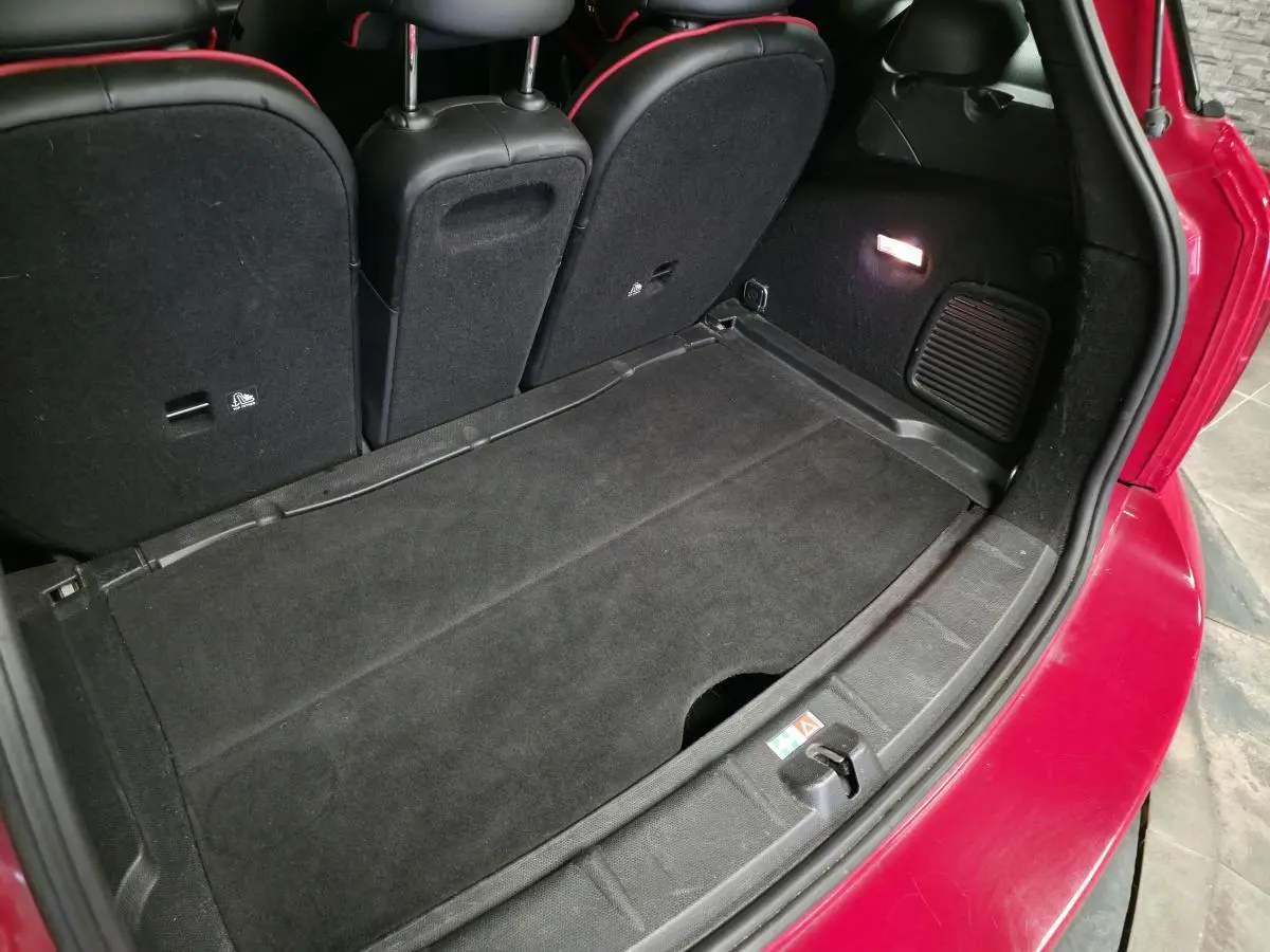 Vue arrière du coffre ouvert d'une MINI Countryman John Cooper Works rouge, montrant l'espace de chargement noir.