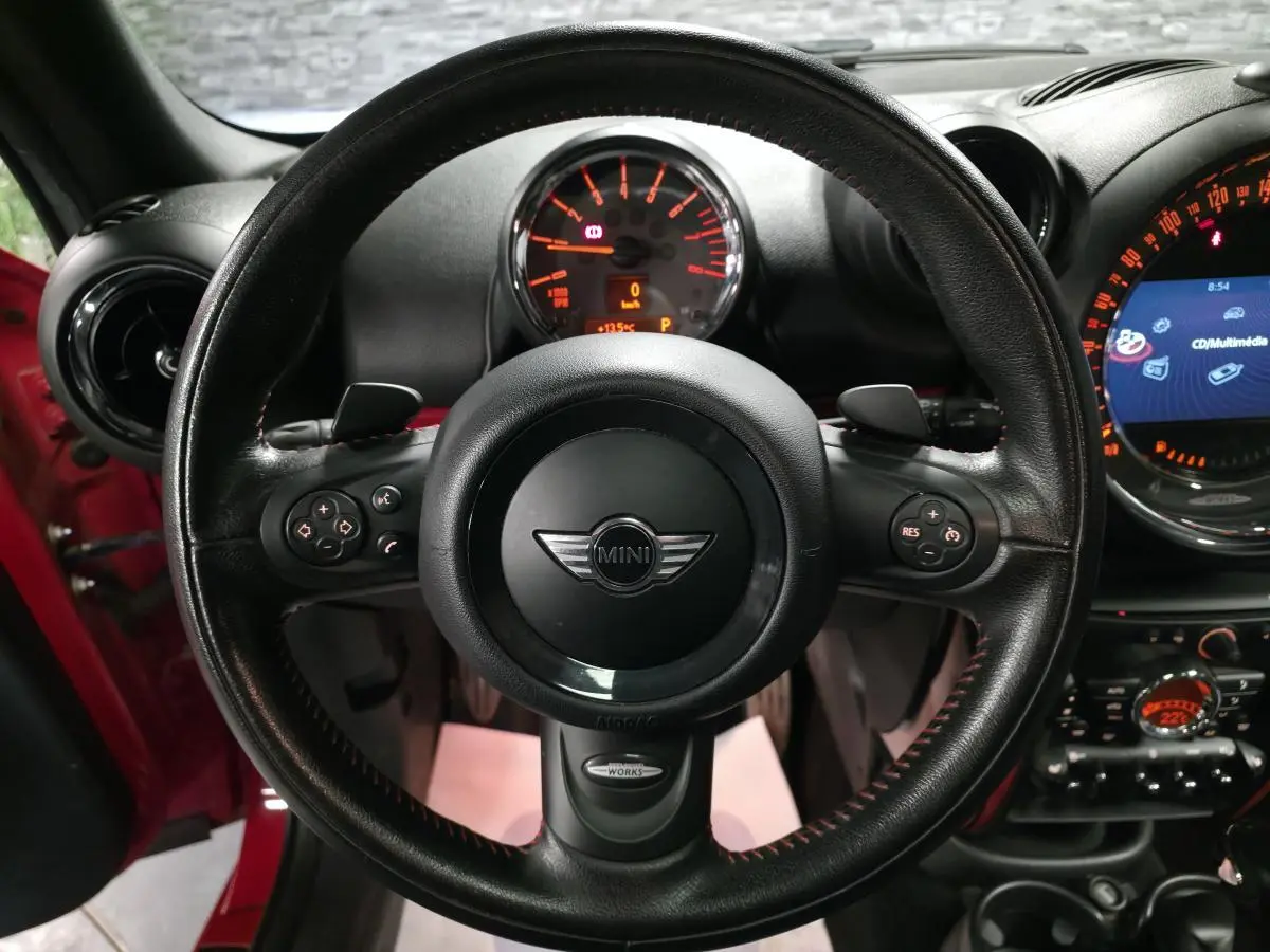 Vue intérieure centrée sur le volant sport noir avec surpiqûres rouges du MINI John Cooper Works rouge de 2015.