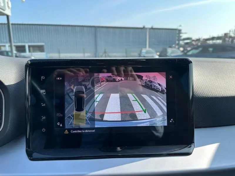 Écran intérieur montrant la caméra de recul du SEAT Arona 2025 avec vue arrière sur un parking et marquages au sol.