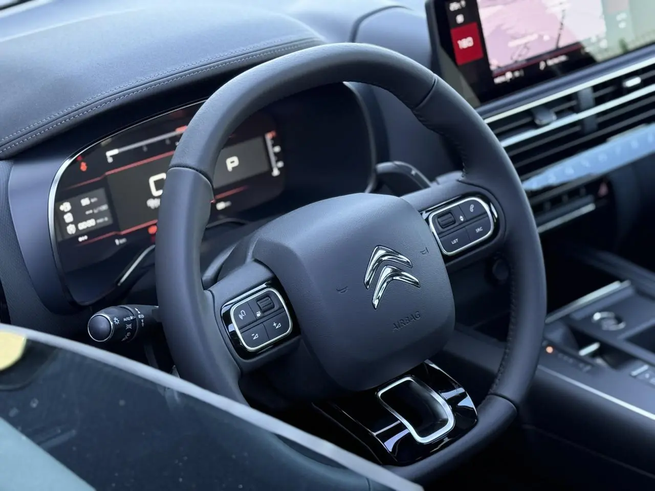 Volant en cuir noir avec commandes intégrées et tableau de bord numérique du Citroën C5 Aircross 2025, ambiance intérieure moderne.