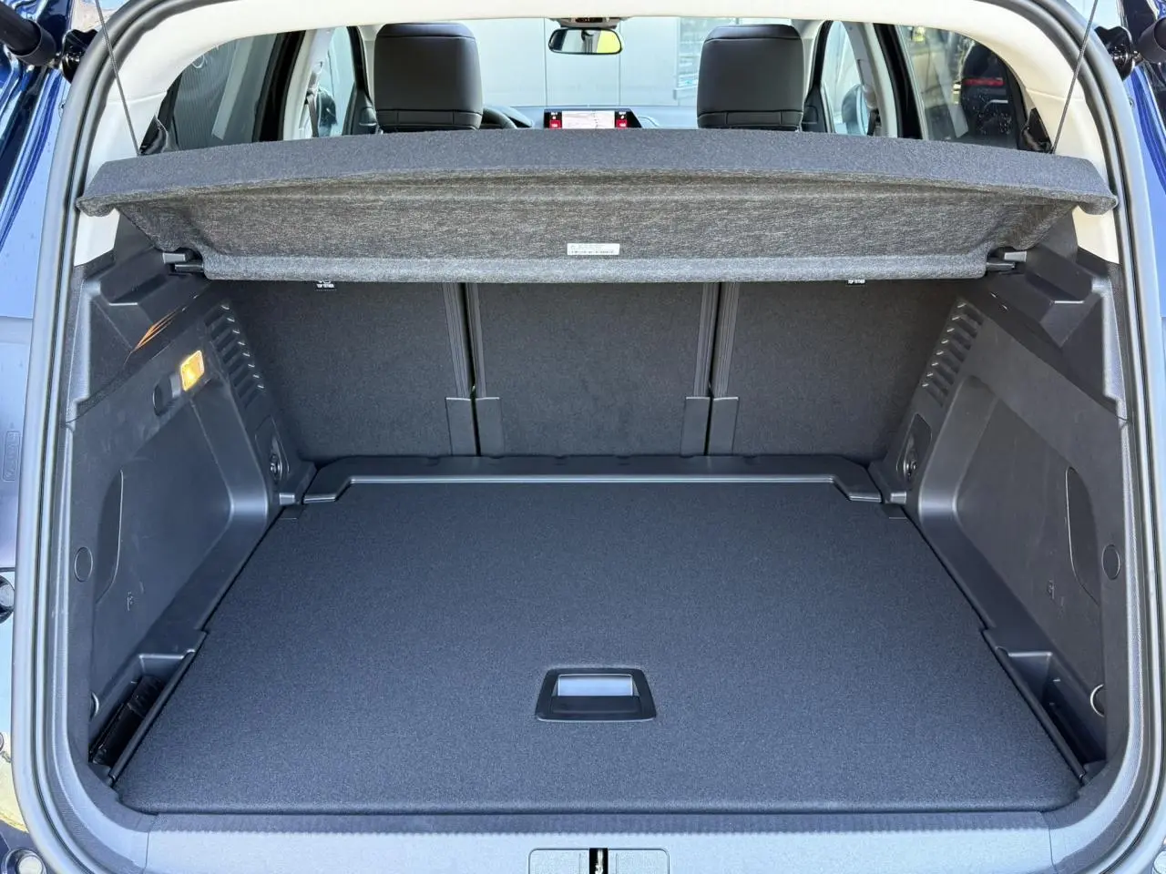 Coffre ouvert vu de l'arrière du Citroën C5 Aircross Bleu Eclipse, avec cache-bagages et banquettes arrière visibles.